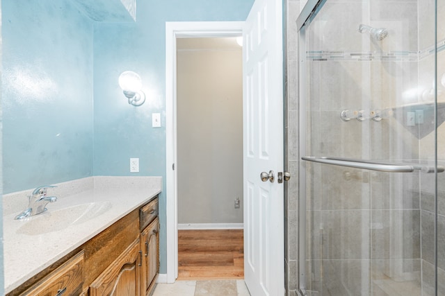 bathroom featuring tile patterned flooring, a shower with door, and vanity