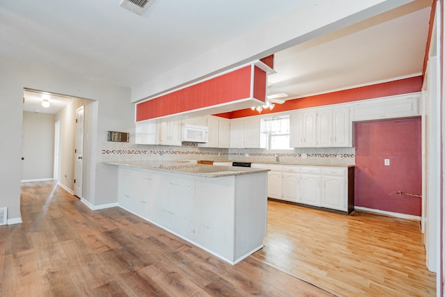 kitchen with kitchen peninsula, white cabinetry, and light hardwood / wood-style flooring