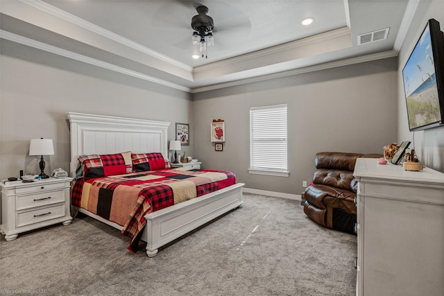 bedroom with ceiling fan, a tray ceiling, ornamental molding, and light carpet