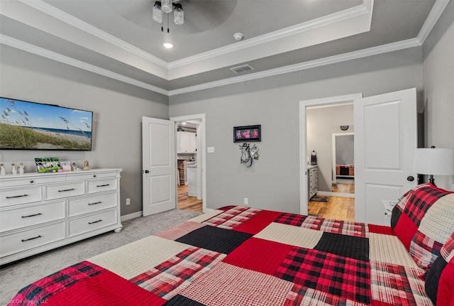 bedroom with ceiling fan, a raised ceiling, crown molding, and light colored carpet