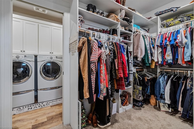 walk in closet featuring light colored carpet and washing machine and clothes dryer