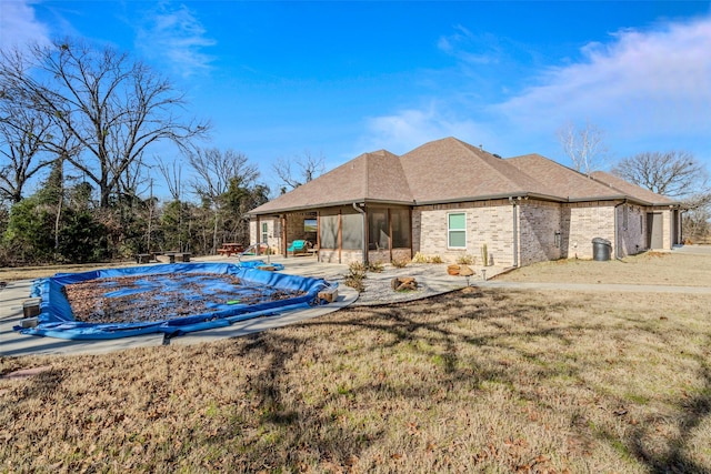 exterior space with a covered pool, a sunroom, a patio, and a yard