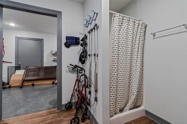 bathroom with hardwood / wood-style flooring and curtained shower