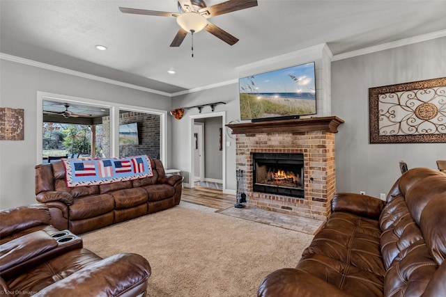 living room featuring ceiling fan, carpet, crown molding, and a fireplace