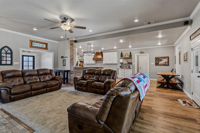 living room with light wood-type flooring and crown molding