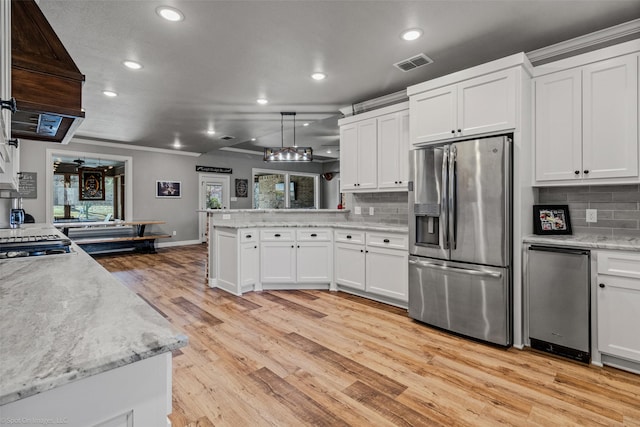 kitchen featuring hanging light fixtures, stainless steel refrigerator with ice dispenser, white cabinets, light wood-type flooring, and backsplash