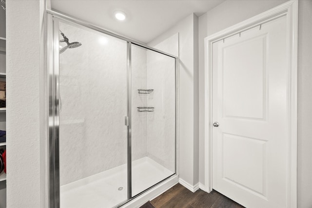 bathroom featuring hardwood / wood-style flooring and an enclosed shower