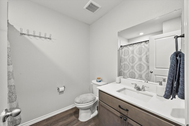 bathroom featuring hardwood / wood-style floors, toilet, curtained shower, and vanity