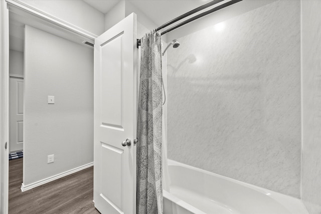 bathroom featuring hardwood / wood-style floors and shower / tub combo with curtain