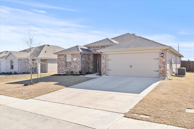 ranch-style home featuring a garage and cooling unit