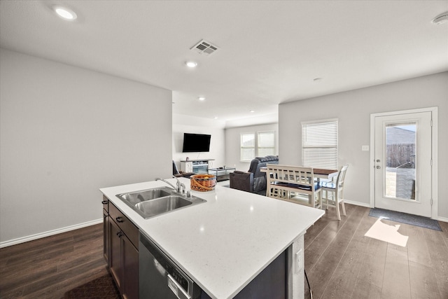 kitchen featuring sink, a kitchen island with sink, dishwasher, and dark hardwood / wood-style flooring