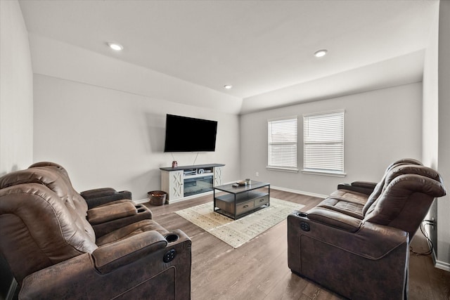 living room with hardwood / wood-style flooring and vaulted ceiling