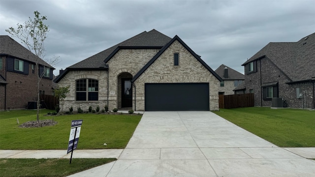 view of front of house featuring a garage, a front yard, and central AC