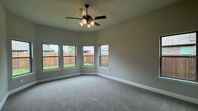 carpeted spare room with plenty of natural light and ceiling fan