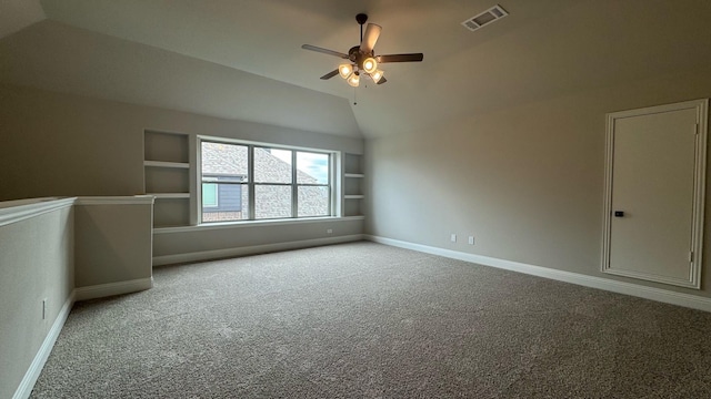 carpeted spare room featuring built in features, ceiling fan, and lofted ceiling