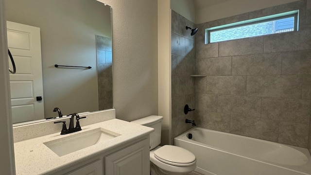 full bathroom featuring toilet, tiled shower / bath, and vanity