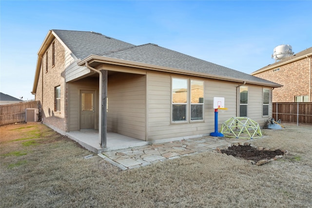 rear view of property featuring central AC, a patio, and a lawn