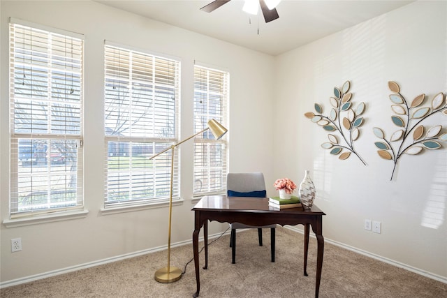 carpeted office space featuring ceiling fan