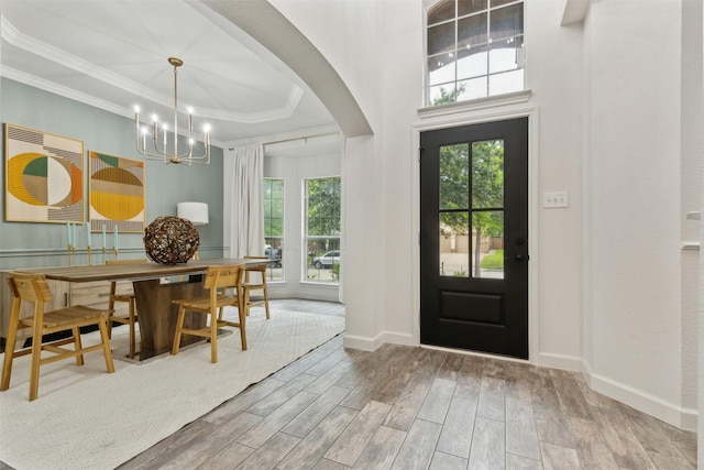 entryway featuring crown molding and an inviting chandelier