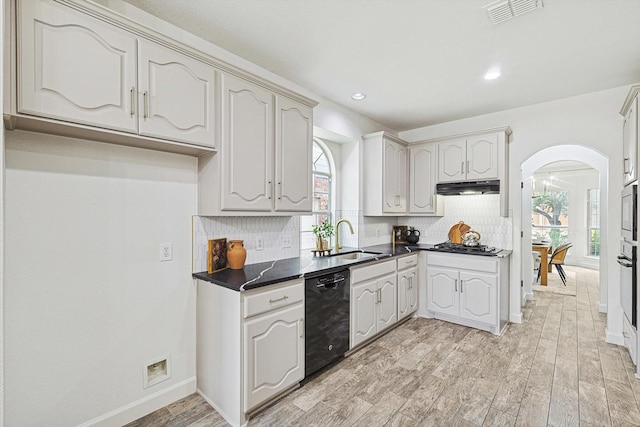 kitchen featuring stainless steel appliances, dark countertops, visible vents, a sink, and under cabinet range hood