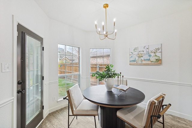 dining room with a chandelier, light wood finished floors, baseboards, and a healthy amount of sunlight