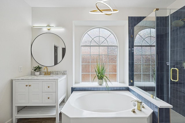 bathroom featuring a bath, a stall shower, and vanity