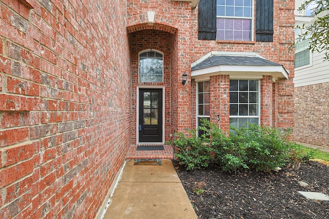 view of exterior entry with brick siding