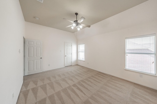 carpeted spare room featuring ceiling fan and lofted ceiling