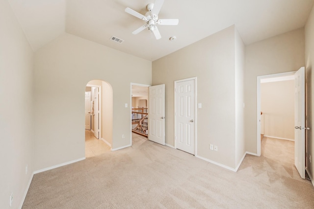 unfurnished bedroom with ceiling fan, high vaulted ceiling, and light carpet