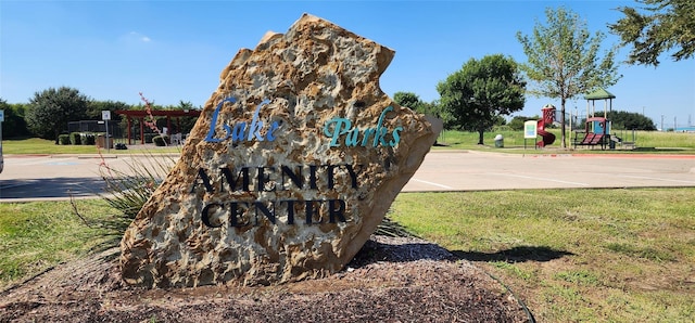 community / neighborhood sign featuring a yard