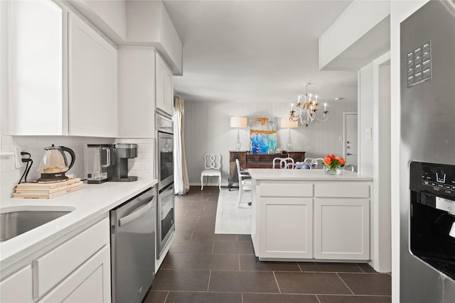 kitchen featuring kitchen peninsula, white cabinets, and stainless steel appliances