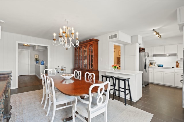 tiled dining area with an inviting chandelier