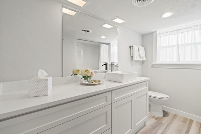 bathroom featuring curtained shower, hardwood / wood-style floors, toilet, and vanity