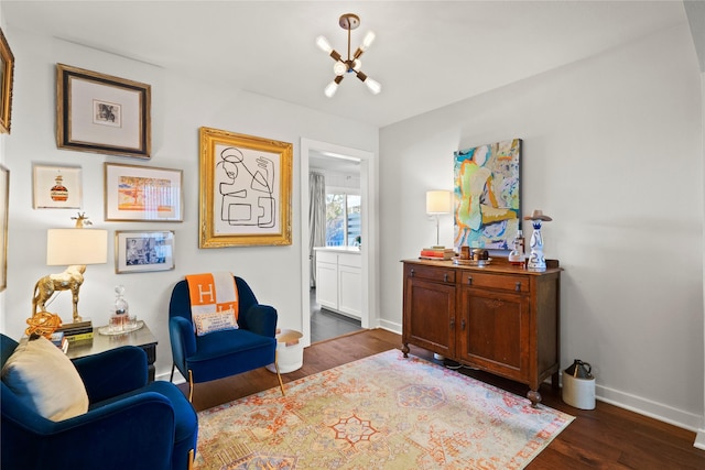 sitting room with dark hardwood / wood-style floors and a chandelier