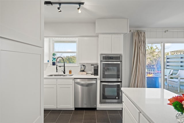 kitchen with sink, white cabinetry, appliances with stainless steel finishes, and a healthy amount of sunlight