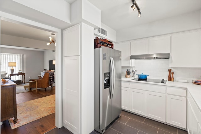 kitchen with black electric stovetop, dark tile patterned flooring, decorative backsplash, white cabinets, and stainless steel refrigerator with ice dispenser