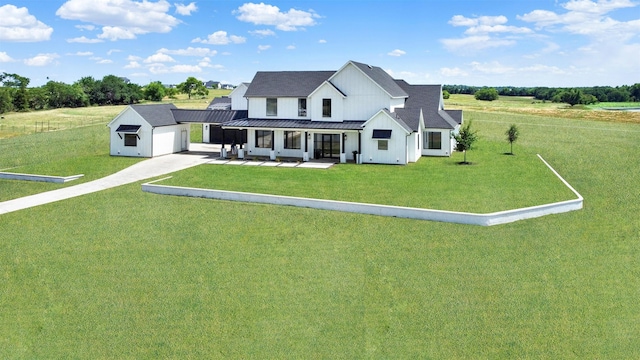 view of front of property featuring covered porch, a garage, and a front lawn