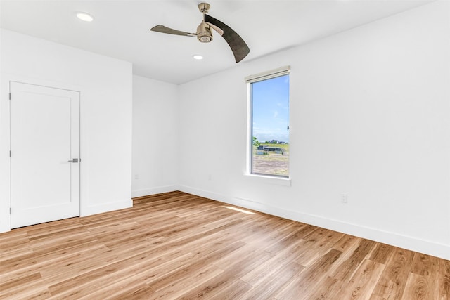 empty room with ceiling fan and light hardwood / wood-style flooring