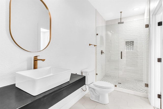 bathroom featuring toilet, vanity, tile patterned floors, and an enclosed shower