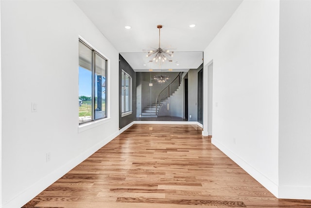 hallway featuring light hardwood / wood-style flooring and a notable chandelier