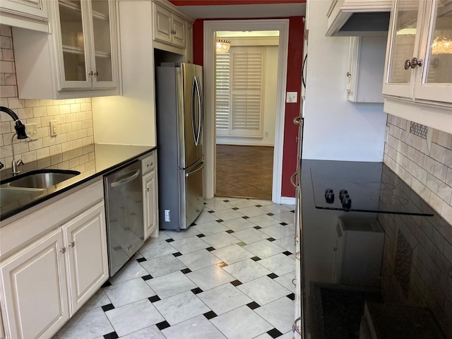 kitchen with decorative backsplash, sink, white cabinetry, and stainless steel appliances