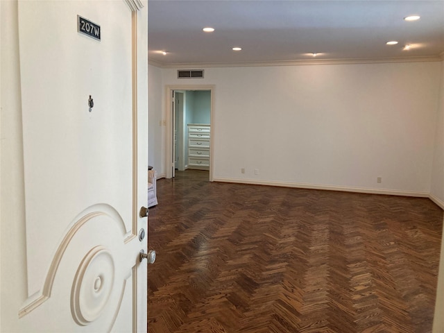 empty room featuring crown molding and dark parquet flooring