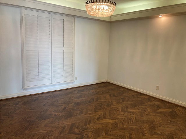 unfurnished room with a notable chandelier and dark parquet floors