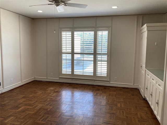 unfurnished room featuring ceiling fan and dark parquet flooring