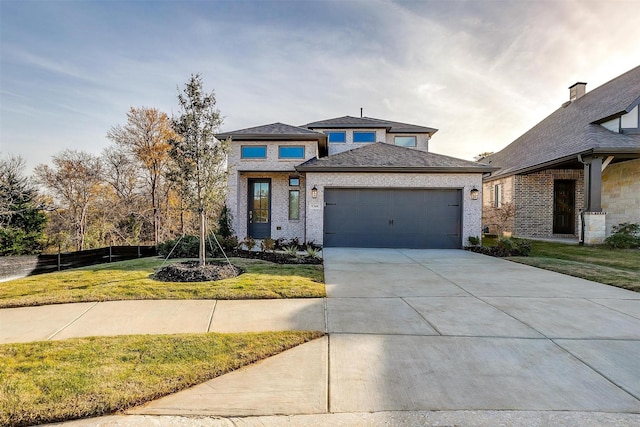 prairie-style house featuring a front yard and a garage