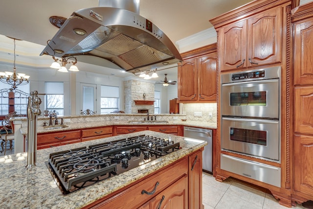 kitchen featuring decorative backsplash, light stone counters, ornamental molding, island range hood, and stainless steel appliances