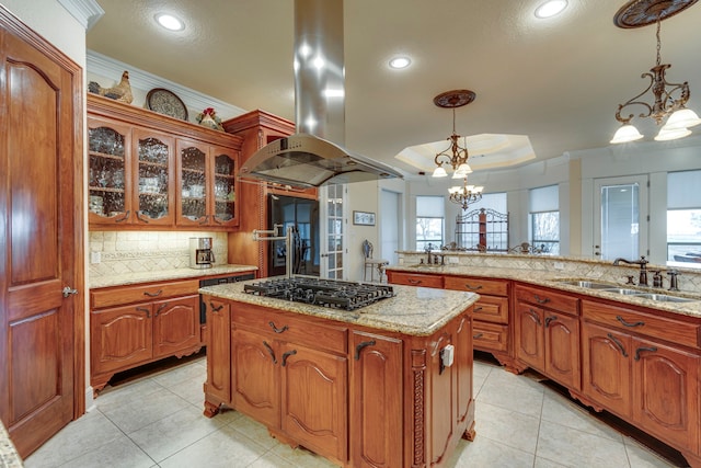 kitchen featuring an inviting chandelier, island range hood, decorative light fixtures, and gas stovetop