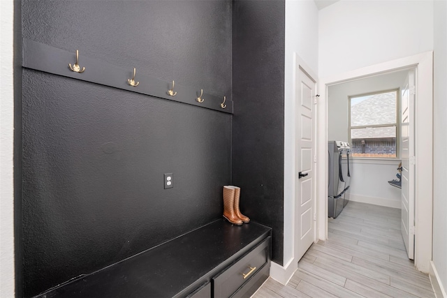 mudroom with light hardwood / wood-style floors and washer and clothes dryer