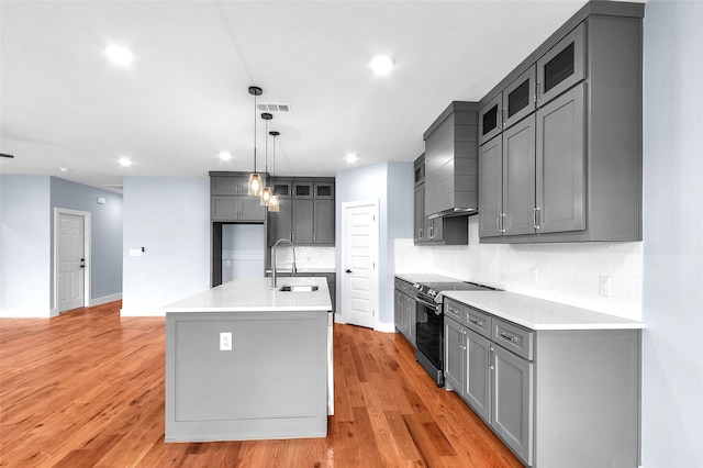 kitchen with black range with electric stovetop, a sink, visible vents, and gray cabinetry