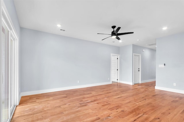 empty room with light wood-style floors, visible vents, and baseboards